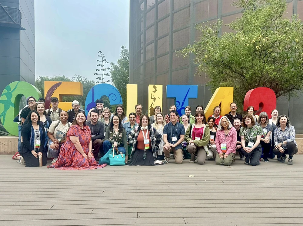 A group of travelers poses in front of the CECUT sign in Tijuana, smiling and enjoying their visit.