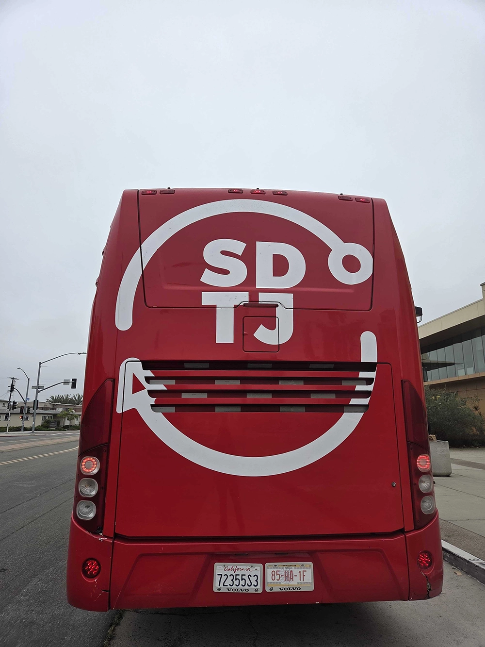Red SD trolley bus viewed from behind, showing the circular SD logo on the back.