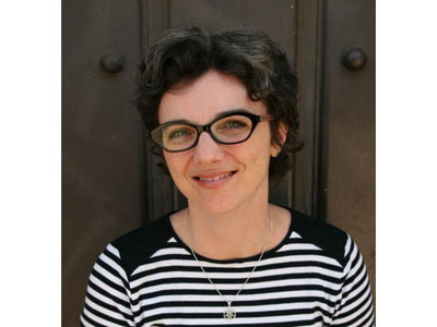 A white woman with salt-and-pepper hair and glasses.