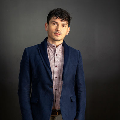 Mexican man with blue blazer and light button shirt. 