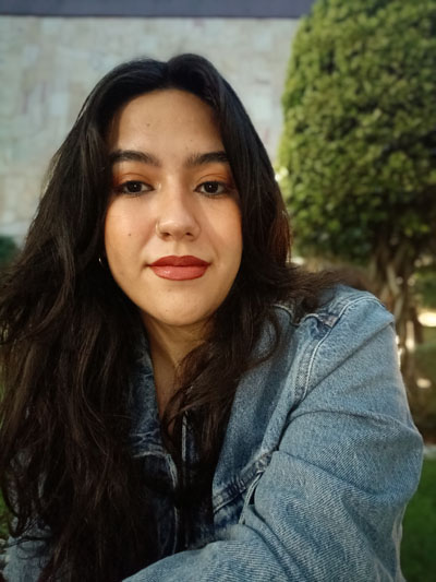 A woman with long black hair wearing a blue denim jacket