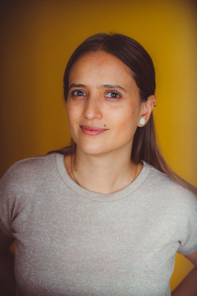 Light skinned woman in her late thirties, with green eyes and long light-brown hair. 