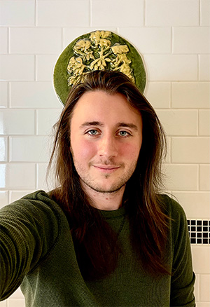 A friendly face with a slight beard and long dark hair.