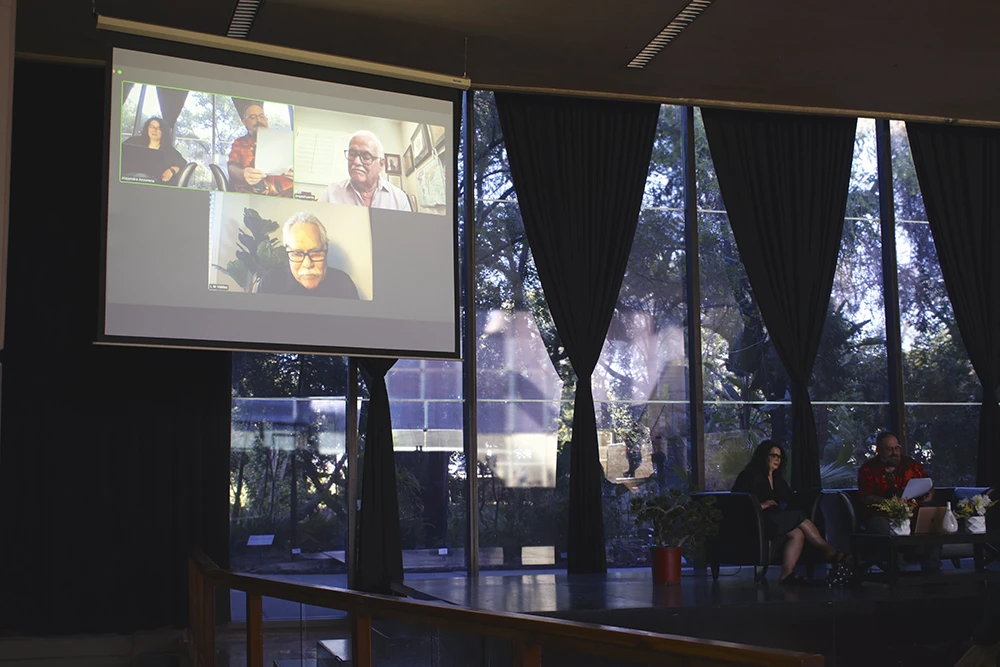 A large screen features a group of people during a plenary session focused on Luis Valdez.
