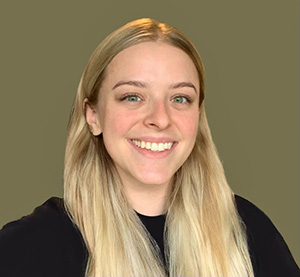 Una joven blanca sonriente con cabello rubio.