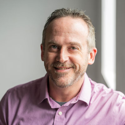 Un hombre blanco con cabello castaño canoso y barba corta. Crédito de la foto: Jenna Selby.