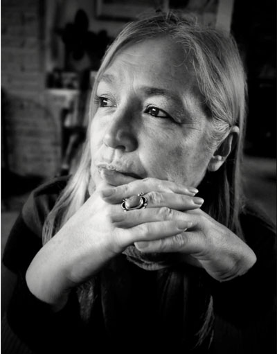 Una mujer blanca con ojos marrones oscuros y cabello largo.